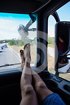 male passenger put his feet on the front panel in the cab of the truck. Hairy legs