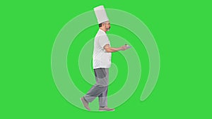 Male pastry chef walking fast with dessert in his hands on a Green Screen, Chroma Key.