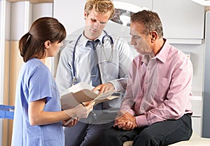 Male Patient Being Examined By Doctor And Intern