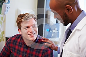 Male Patient Being Reassured By Doctor In Hospital Room photo