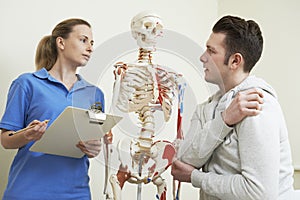 Male Patient Describing Injury To Osteopath photo