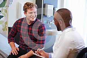 Male Patient And Doctor Have Consultation In Hospital Room photo