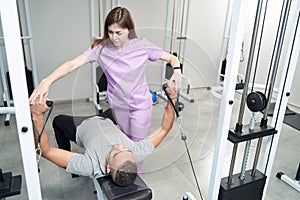 Male patient doing physiotherapy exercise with doctor in clinic