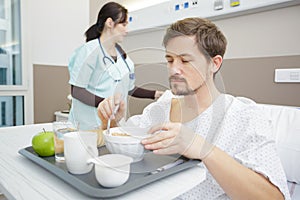 male patient eating meal in hospital bed