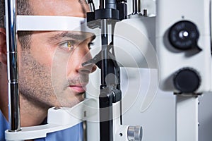 Male patient getting his cornea checked with slit lamp