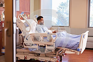 Male Patient In Hospital Bed Using Cellphone