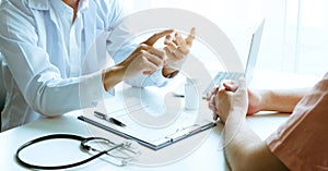 Male patient listening to doctor at desk and consulting with healthcare in hospital