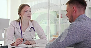 Male patient listening to doctor writing prescription