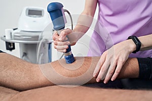 Male patient receiving extracorporeal shockwave therapy in clinic