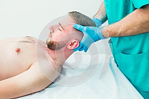 Male patient receiving massage from therapist. A chiropractor stretching his patient`s neck in medical office. Neurological