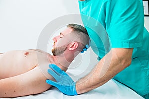 Male patient receiving massage from therapist. A chiropractor stretching his patient`s neck in medical office. Neurological