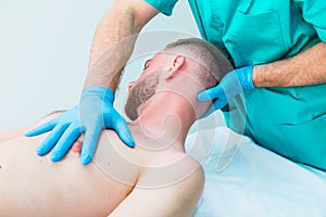 Male patient receiving massage from therapist. A chiropractor stretching his patient`s neck in medical office. Neurological