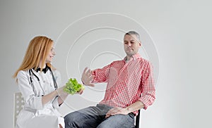 The male patient refuses healthy food offered by a nutritionist. Healthy plant food dietetics photo