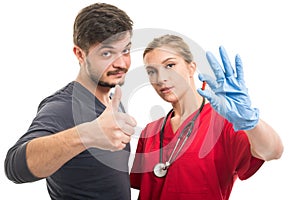 Male patient showing like and female doctor holding pill