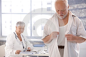 Male patient undressing at doctor's room photo