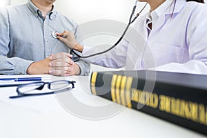 Male Patient Visiting Doctor`s Office listening to checking pati