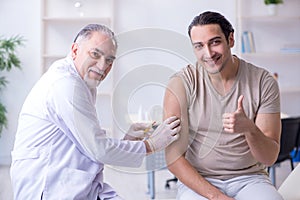 Male patient visitng doctor for shot inoculation