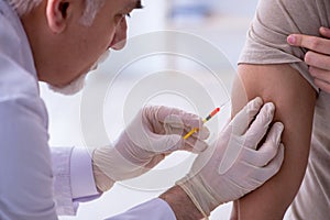 Male patient visitng doctor for shot inoculation