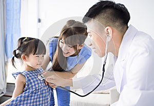 Male pediatrician hold stethoscope exam child girl patient visit doctor with mother