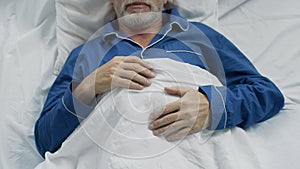 Male pensioner sweetly sleeping in bed, enjoying comfort on orthopedic bed