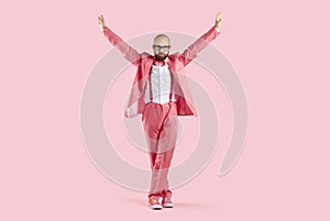 Male performer in pink suit dancing in studio