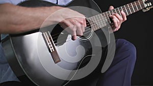 male performer plays a musical melody on the guitar, close-up