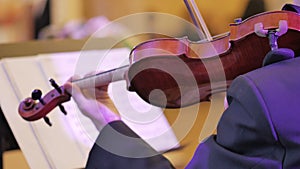 Male performs lead violin sole part playing at classical concert.