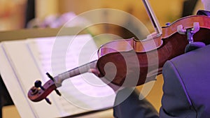 Male performs lead violin sole part playing at classical concert.