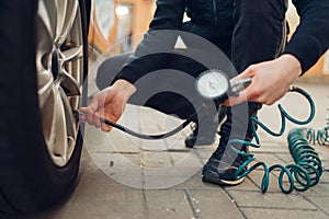 Male person checks the tire pressure, tyre service