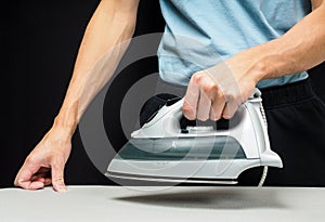 Male person using a steaming hot iron