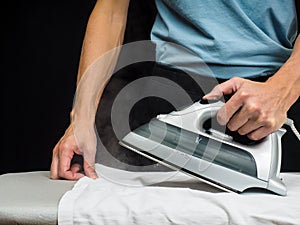 Male person using a steaming hot iron