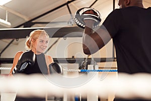 Male Personal Trainer Sparring With Female Boxer In Gym Using Training Gloves