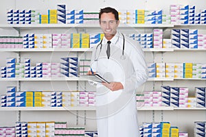 Male Pharmacist Holding File In Pharmacy