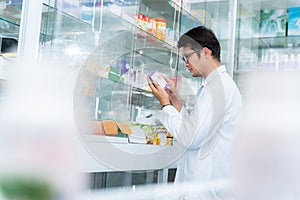 A male pharmacist holding prescription checking medicine in pharmacy or drugstore, Medical healthcare concept