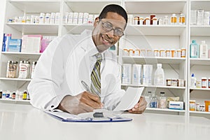 Male Pharmacist Working In Pharmacy