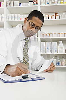 Male Pharmacist Working In Pharmacy