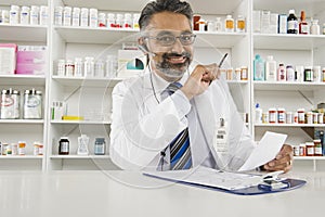 Male Pharmacist Working In Pharmacy