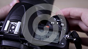 Male photographer adjusts settings on DSLR camera close up