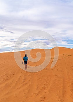 Male photographer with flynet walking across a sand dune