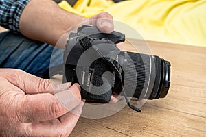 Photographer placing an sd memory card in a professional still camera