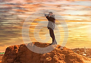 A male photographer on a rock