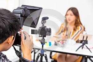 Male photographer taking behine the scene picture for an online buseness woman promoting online beauty products