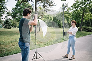 Male photographer taking photos outdoor using dslr camera.