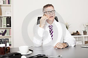 Male Physician Calling Client Through Phone