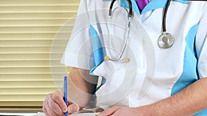 Male physician doctor writing rx prescription on clipboard for his patients