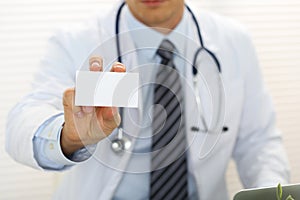 Male physician hand holding and giving white blank calling card