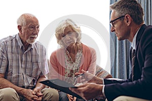 Male physician interacting with senior couple at retirement home