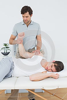 Male physiotherapist examining a young mans hand