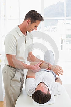 Male physiotherapist examining a young mans hand