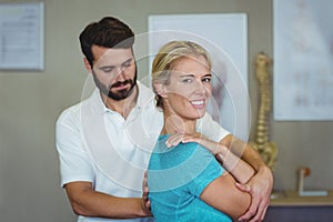 Male physiotherapist giving arm massage to female patient